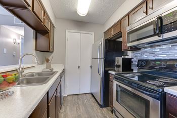 A kitchen with a white fridge and black stove.